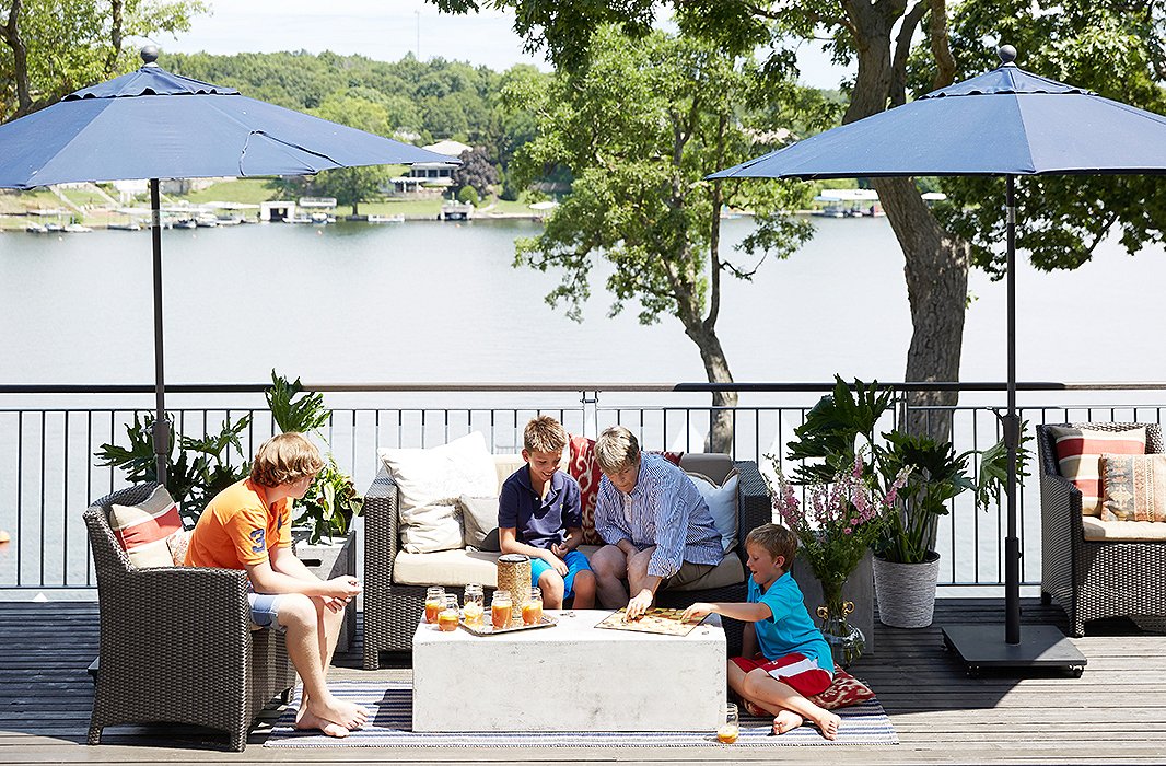 Family relaxing on a lakefront patio overlooking Lake Lotawana